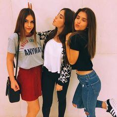 three girls standing next to each other in front of a white wall with the caption foto