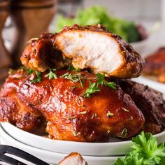 two white plates topped with meat covered in sauce and garnished with parsley