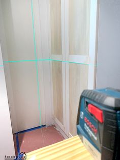 a tool is sitting on top of a piece of wood in the corner of a room