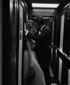 a man and woman are standing in an elevator looking into each other's eyes