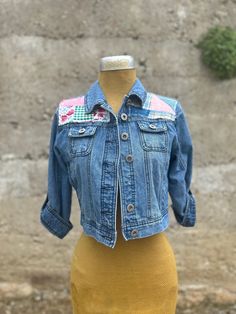 a mannequin with a jean jacket on it's chest and yellow dress underneath