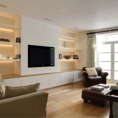 a living room filled with furniture and a flat screen tv mounted on a wall above a fireplace