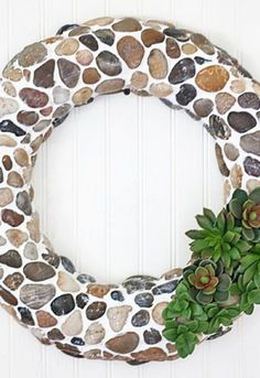 a wreath made out of rocks with succulents on the front and side