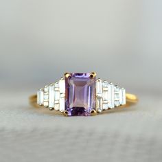 "1.08 Ct emerald cut natural Amethyst gemstone, with baguette and princess cut natural diamonds, this art deco inspired ring is all the rage! It makes for a gorgeous engagement ring and a family heirloom.. :) A perfect piece of birthstone jewelry to own for the February born ladies! * Center Gemstones : Natural Amethyst * Stone Shape : Emerald Cut * Stone Wt. : 0.1.08 ct * Accent Gemstone : Natural Diamonds * Diamond Wt. : 0.26 Cts * Color-Clarity Grade : H-I, Vs-Si * Gold - 14k, 2.81 gms gold ( Art Deco Jewelry With Rectangular Baguette Diamonds, Art Deco Baguette Diamond Rectangular Ring, Art Deco Rectangular Baguette Diamond Ring, Elegant Purple Amethyst Baguette Cut Ring, Elegant Purple Baguette Cut Amethyst Ring, Elegant 14k Gold Rectangular Amethyst Ring, Elegant Lavender Emerald-cut Ring, Elegant Amethyst Baguette Cut Ring, Elegant Lavender Amethyst Ring Emerald Cut