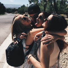 black and white photograph of four women hugging each other on the side of the road