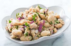 a white bowl filled with food on top of a table