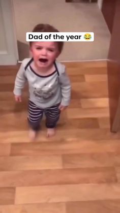 a toddler standing on the floor with his mouth wide open and tongue out, saying dad of the year