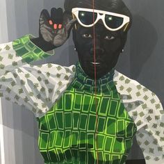 a mannequin wearing green and white clothing with sunglasses on it's head