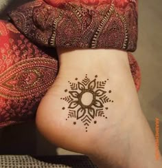 a woman's foot with a henna tattoo on it