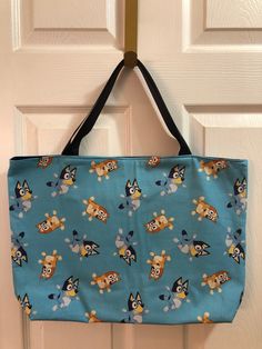 "This Bluey and Bingo tote bag is made of cotton and is machine washable. It is fully lined and interfaced and has 2-18\" navy straps. It measures 14\" down by 18\" across. It will make a great gift for any Bluey fan." Blue Canvas School Bag With Adjustable Strap, Blue Canvas Bag With Adjustable Strap For School, Blue Shoulder Diaper Bag For Daily Use, Blue Shoulder Diaper Bag For Everyday, Blue Everyday Shoulder Diaper Bag, Everyday Blue Shoulder Diaper Bag, Blue Canvas Beach Bag For Shopping, Blue Rectangular Diaper Bag With Adjustable Strap, Blue Canvas School Bag