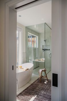 a bathroom with a bathtub, rug and shower stall in it's corner