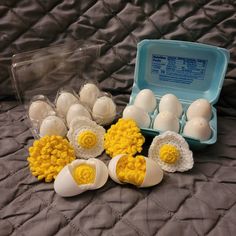 an egg tray with nine eggs in it on a bed next to some plastic containers