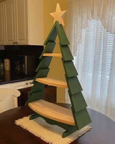 a wooden christmas tree sitting on top of a table next to a kitchen countertop