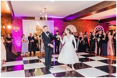 a bride and groom walking down the dance floor in front of their guests at a wedding