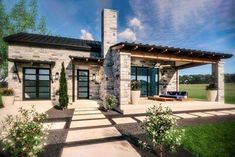 a house that is sitting in the grass with a porch and covered patio area next to it