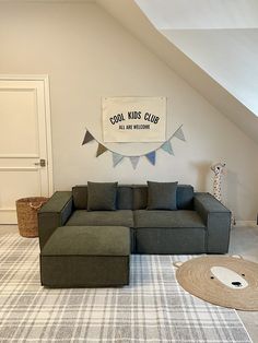 a living room with a large sectional couch and rug on the floor in front of it