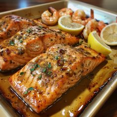 some salmon and shrimp on a tray with lemons