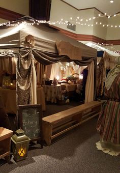 an old fashioned tent is set up in the middle of a room with tables and chairs