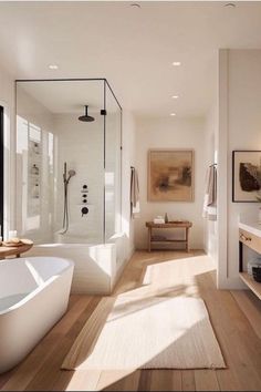 a bathroom with a large tub and wooden floors