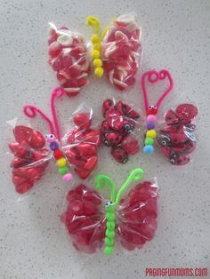 some plastic butterflies are sitting on the counter top, and one is red with yellow dots