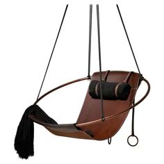 a brown leather chair hanging from a metal pole