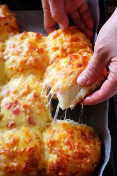 a person taking a piece of cheese pizza from a pan