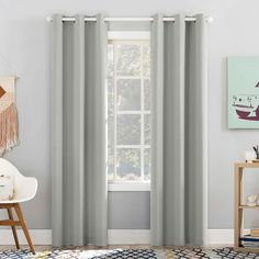 a living room with grey curtains and a white chair