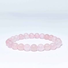 This beautiful Rose Quartz Bead Bracelet shows off the warm pinks and rose tones of Rose Quartz. This bracelet is associated with love and caring emotions and is said to bring love and friendship to those who wear and meditate upon it. The round beads are strung on the elastic thread to fit any wrist and are selected for their quality and richness of color. This bracelet is a perfect accessory for any outfit and easy to you wherever you go. Natural Stones Jewelry, Rose Quartz Bracelet Beads, Quartz Crystal Jewelry, Bracelets With Meaning, Love And Friendship, Stones Jewelry, Elastic Thread, Love Energy, Rose Quartz Bracelet