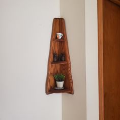 a wooden shelf with two shelves on it and a potted plant in the corner