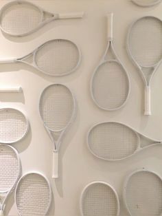 several tennis rackets lined up on a wall