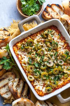 a casserole dish filled with vegetables and bread