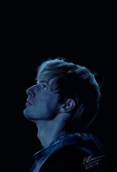 a young man with his eyes closed in the dark, looking up into the sky