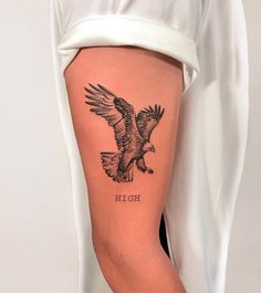 a woman's leg with an eagle tattoo on it, and the words hot ii written in black ink