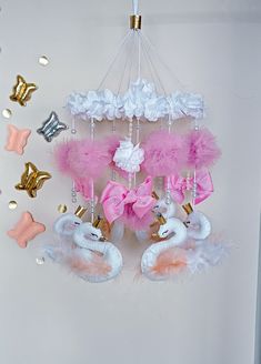 some pink and white decorations hanging from a ceiling