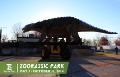 a large dinosaur statue sitting in the middle of a parking lot