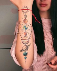 a woman is holding her arm up to show the tattoo design on her left arm