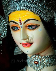 a close up of a statue of a woman with jewelry on it's face