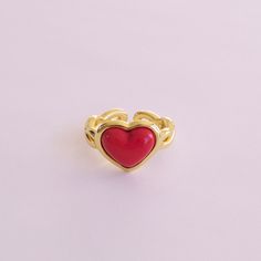 Made from delicate porcelain, this ring features a vibrant red heart-shaped centrepiece that captures the essence of love and romance. The rich, deep red hue adds a touch of warmth and passion, making it a perfect accessory for any occasion. The heart is encased in a 18K gold-plated setting and a braided band.   MATERIAL Handmade porcelain  18K Gold-plated brass    SIZE & FIT Ring size: EU 54/US 7 Ring diameter: 17. 2mm Product size: 14mm x22mmx25mm  COLOUR Red, gold  WEIGHT 6g   Handmade in Den Red Enamel Elegant Rings, Red Enamel Jewelry For Valentine's Day, Red Open Ring For Valentine's Day, Red Heart Ring For Valentine's Day, Elegant Red Enamel Ring, Enamel Heart Shaped Promise Ring, Valentine's Day Red Heart Ring, Red Enamel Ring For Gift, Red Enamel Rings For Gift