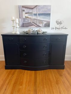 a black dresser sitting on top of a hard wood floor