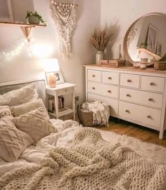 a bedroom with a bed, dresser and mirror on the wall next to each other