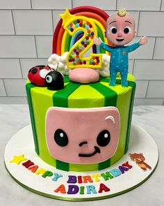 a birthday cake with an image of a child's face on top and toys around it