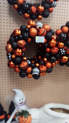 halloween decorations are hanging on the wall next to a teddy bear and pumpkin wreaths