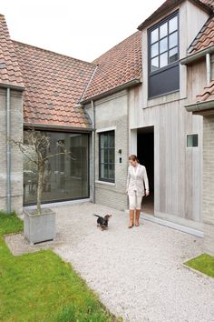 a woman walking into a house next to a cat