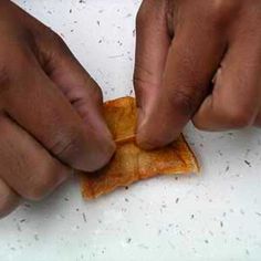 two hands that are holding some kind of piece of bread