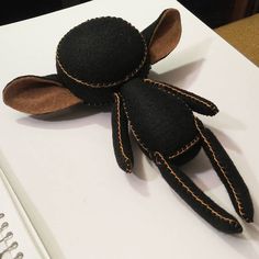 a black stuffed animal sitting on top of a white table