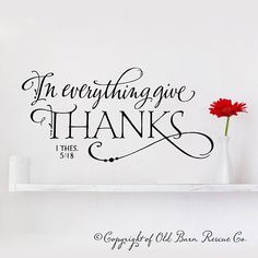 a wall decal with the words in everything give thanks, and a red flower