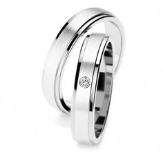 two white gold wedding rings with diamonds on each side and one diamond in the middle