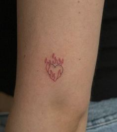 a woman's leg with a heart tattoo on the lower half of her arm