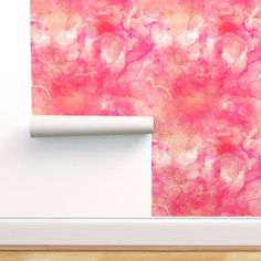 pink and white wallpaper in an empty room with wood flooring next to it