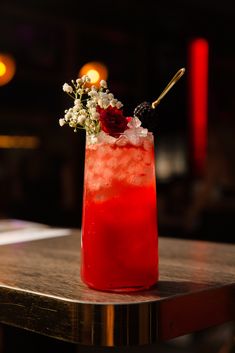 a red drink with flowers in it sitting on a table